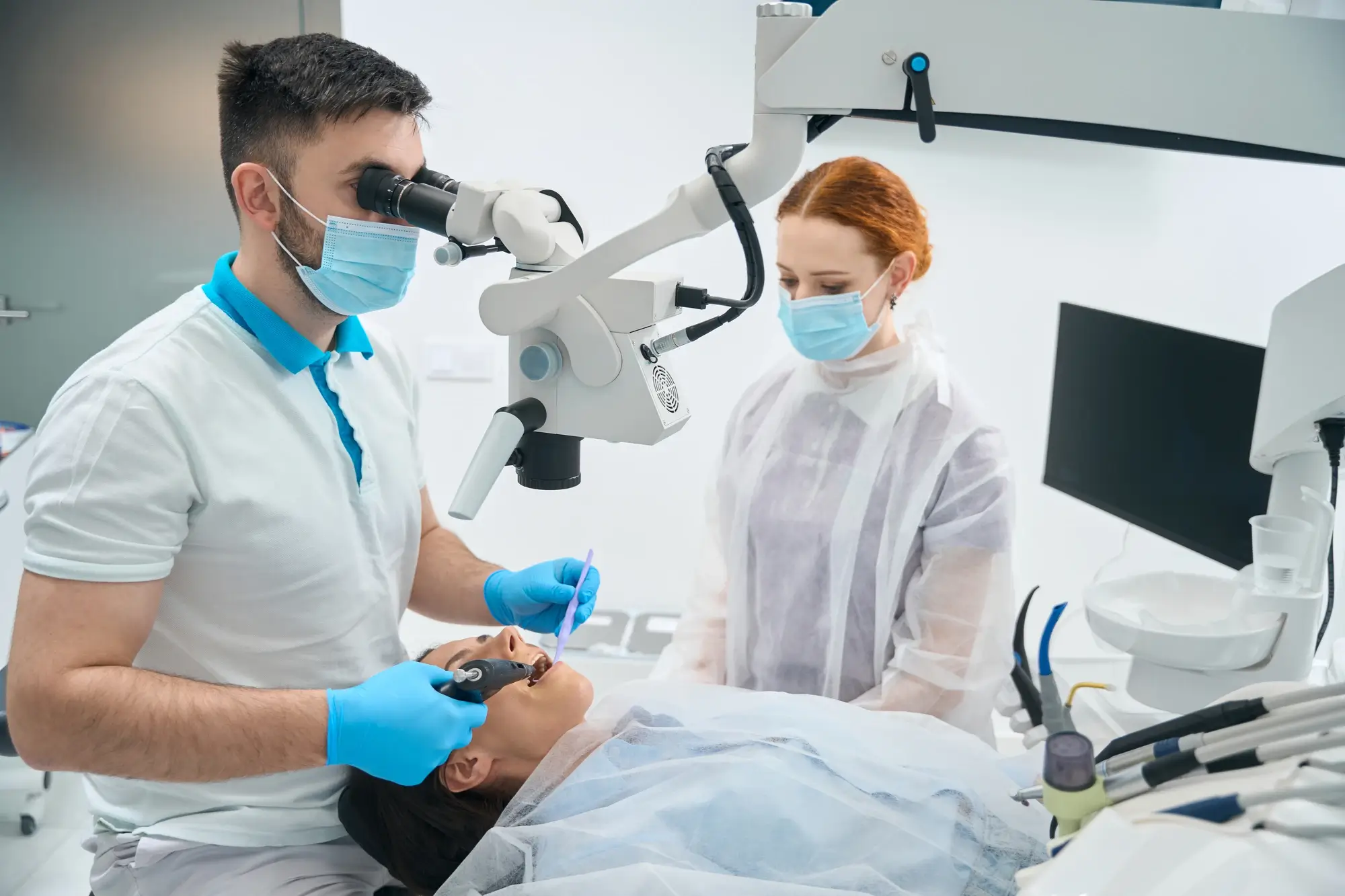 Un dentista sta eseguendo un intervento chirurgico su un paziente per rimuovere un impianto.