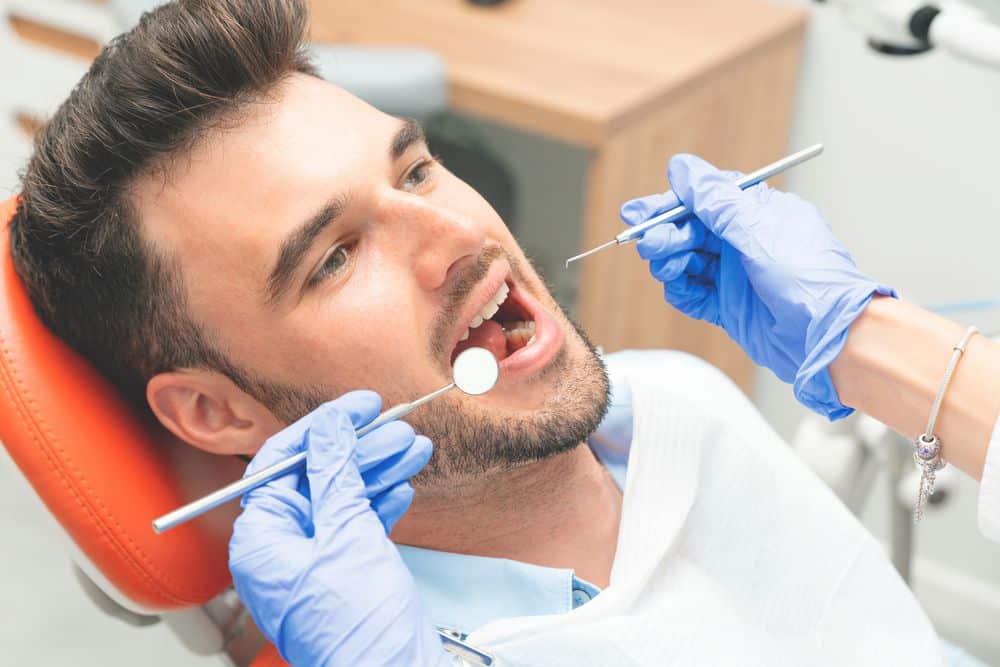 Dentista OrthoDental esegue una visita di controllo a un paziente durante la prima visita